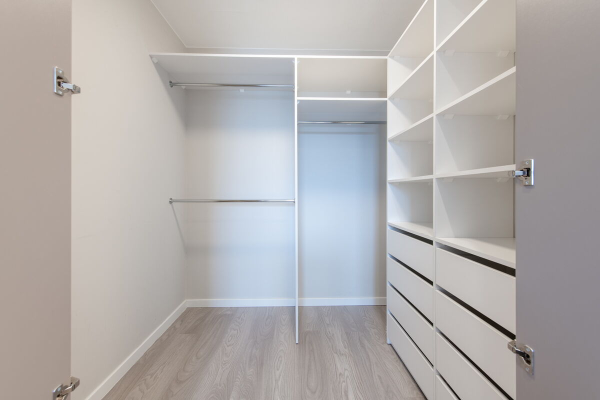 Funktionaler begehbarer Kleiderschrank in Nebenraum vom Tischler gefertigt.